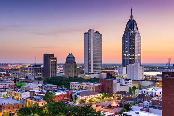 Mobile AL skyline at dusk with a colorful sunset