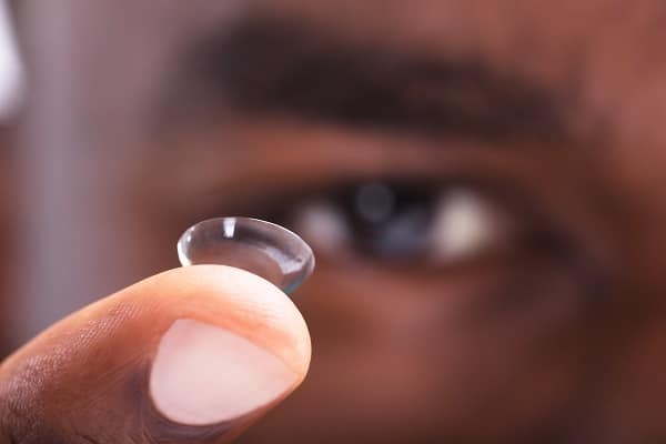 Close up of a man's finger balancing a contact lens