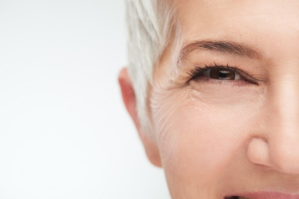 Close up a smiling woman and her eye after cataract surgery