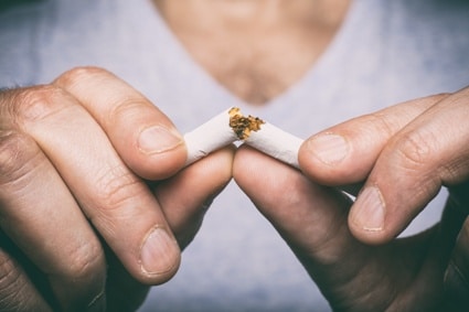 man breaking cigarette in two - stop smoking for healthier eyes